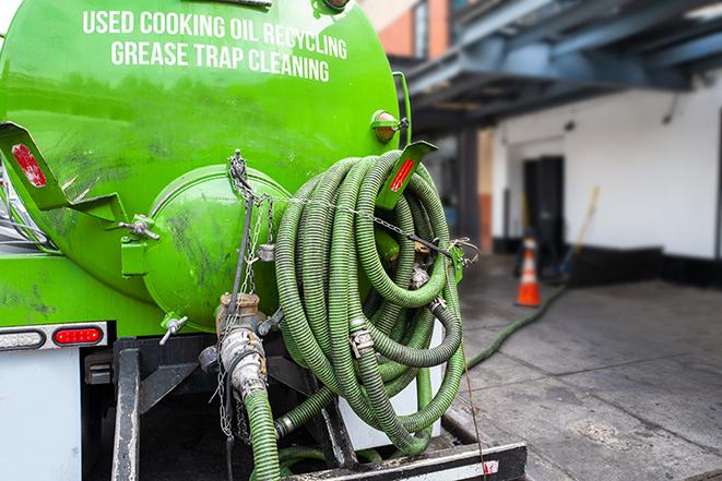 a technician pumping a grease trap in a commercial building in Garrison